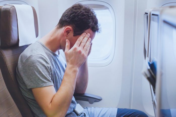 headache in the airplane, man passenger afraid and feeling bad during flight, fear